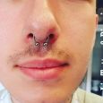 A horse shoe shaped septum piercing on a guy