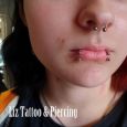 A septum and snake bite piercings on a girl