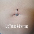 A bellybutton piercing with a white crystal