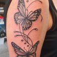 Butterflies in black and grey on upper arm