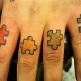 Puzzle pieces tattooed on the fingers