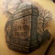 A back tattoo of a graveyard and a tombstone