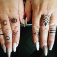 Small black finger tattoos